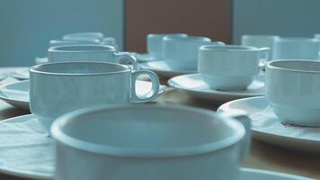 A table with many white cups and saucers video