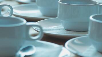 A table with many white cups and saucers video