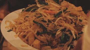 A plate of noodles with vegetables and meat on it video