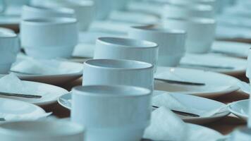Many white cups and saucers are arranged on a table video