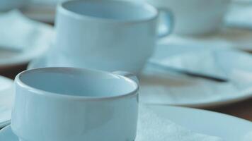 A table with a bunch of white cups and saucers video