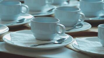 A table with many white cups and saucers video