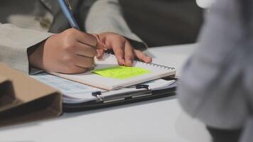 A person writing on a notepad with a pen video