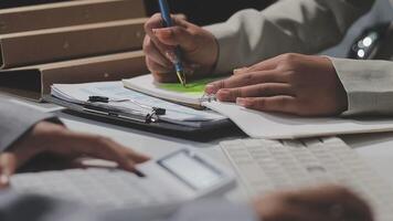 en person är skrivning på en bit av papper medan annan person är använder sig av en kalkylator video