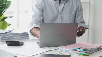 A man sitting at a desk with a laptop and papers video