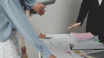 três o negócio pessoas em pé por aí uma mesa com papéis video