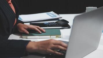 A person typing on a laptop computer with a notebook video