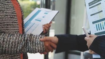 Two business people shaking hands with papers in front of them video