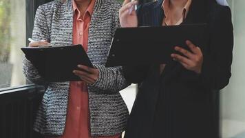 Two business women standing next to each other with their laptops video