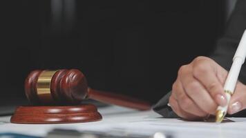 A judge's gavel on a desk with a pen and paper video