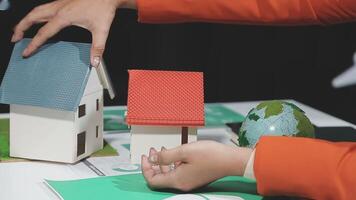 A person is holding a house model on a table video