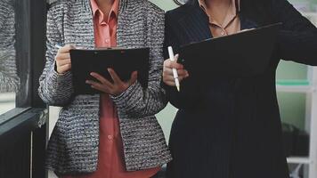 Two business women standing next to each other with a clipboard video