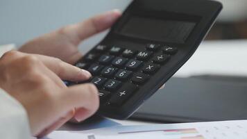 A person is using a calculator to calculate the numbers video