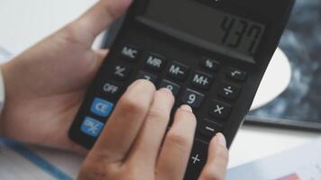 A person is using a calculator to calculate the numbers video