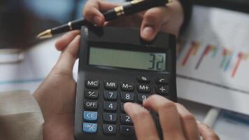A person is using a calculator to calculate the numbers video