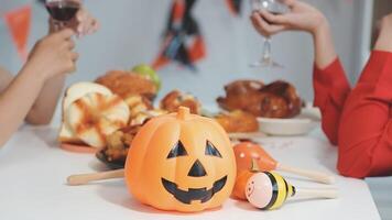 A group of people sitting at a table with a pumpkin and wine video
