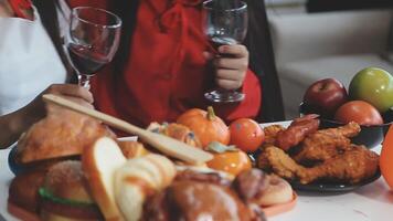 Two people toasting with wine glasses on a table with food video