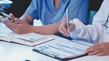Two doctors are working on paperwork at a desk video
