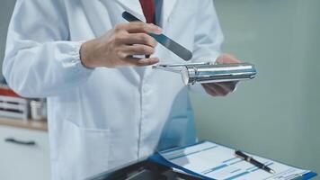 A man in a lab coat is holding a metal object video