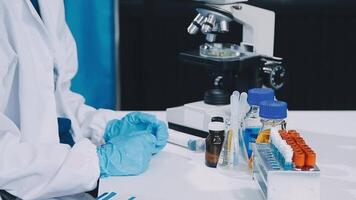 A person in a lab coat is working on a microscope video