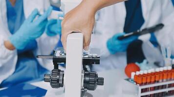 A person in a lab coat is holding a microscope video