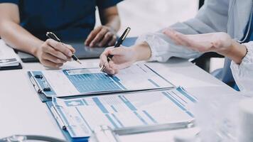 Two doctors are working on paperwork at a desk video