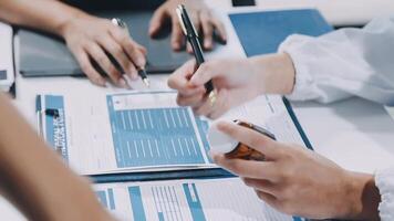 A group of people sitting at a table with papers and pens video