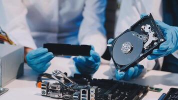 Two people working on a computer with a hard drive video