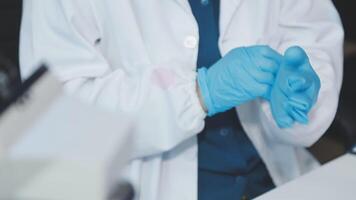 A person in a lab coat and blue gloves video