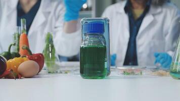 Two people in lab coats are holding bottles of liquid video