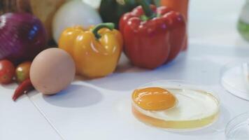 A white table with an egg, vegetables and other ingredients video