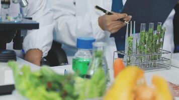 A man in a lab coat is writing on a clipboard video