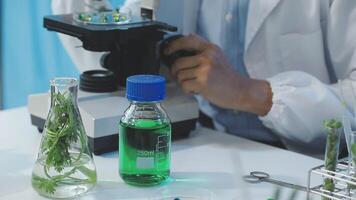 A man in a lab coat is looking at a green liquid video