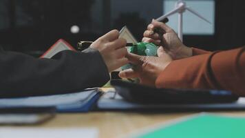 Two people sitting at a table with a green globe video