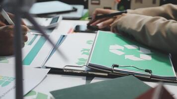 A person is working on a document with a recycling symbol on it video