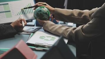 Business people working on a project with a globe and a recycling symbol video