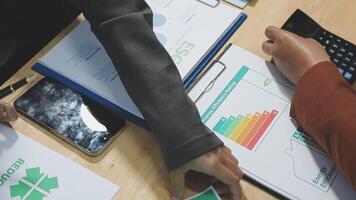 Business people working on a spreadsheet with a calculator video