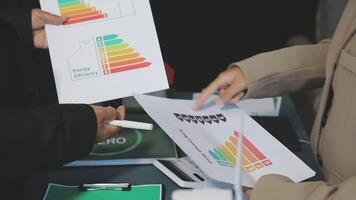Two people holding papers with energy efficiency information video