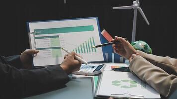 Business people working on a presentation with a calculator and a paper with graphs video