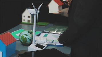 A man in a suit is holding a wind turbine video