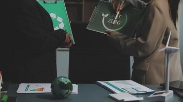 Two people in business attire holding papers and a green folder video