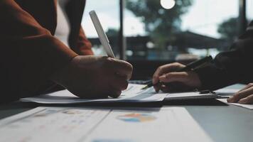 Two people are working on a document with a pen video