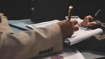Two people are working on a document with a pen and paper video