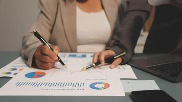 Two business people are working on a document with graphs and charts video