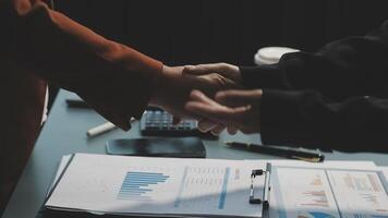 Two people shaking hands over a desk with papers video