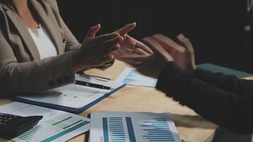 Two business people shaking hands at a table video