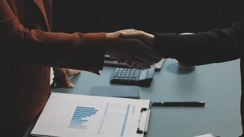 Two business people shaking hands over a desk video