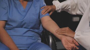 A nurse is holding the arm of a patient video