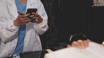 A doctor is using a cell phone while looking at a patient video