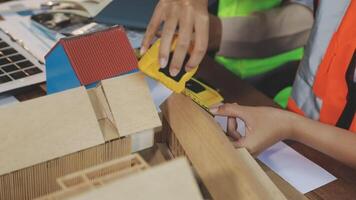 A man is using a measuring tape to build a house video